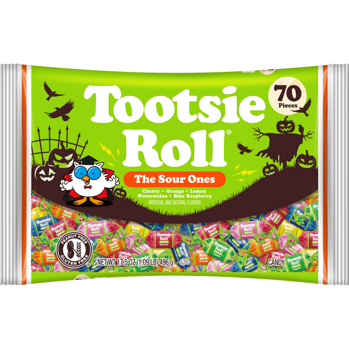 A bag of Tootsie Roll 'The Sour Ones' sour candy, featuring a bright green Halloween-themed wrapper with illustrations of pumpkins, a witch, bats, and a cartoon character. The wrapper indicates 70 pieces and shows a clear window displaying the colorful individually wrapped candies inside.